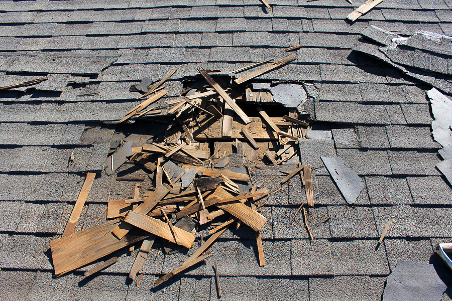 View of brown two story house against blue sky with gables windows and clean roof.