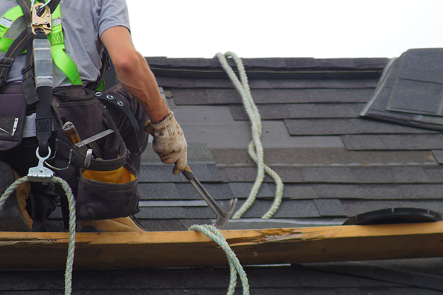 Professionally laid red asphalt shingle rectangular shape on a clean roof 